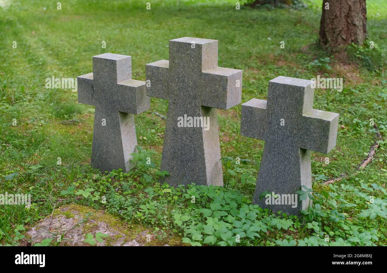 Tres cruces de piedra en un cementerio en el bosque. Foto de stock