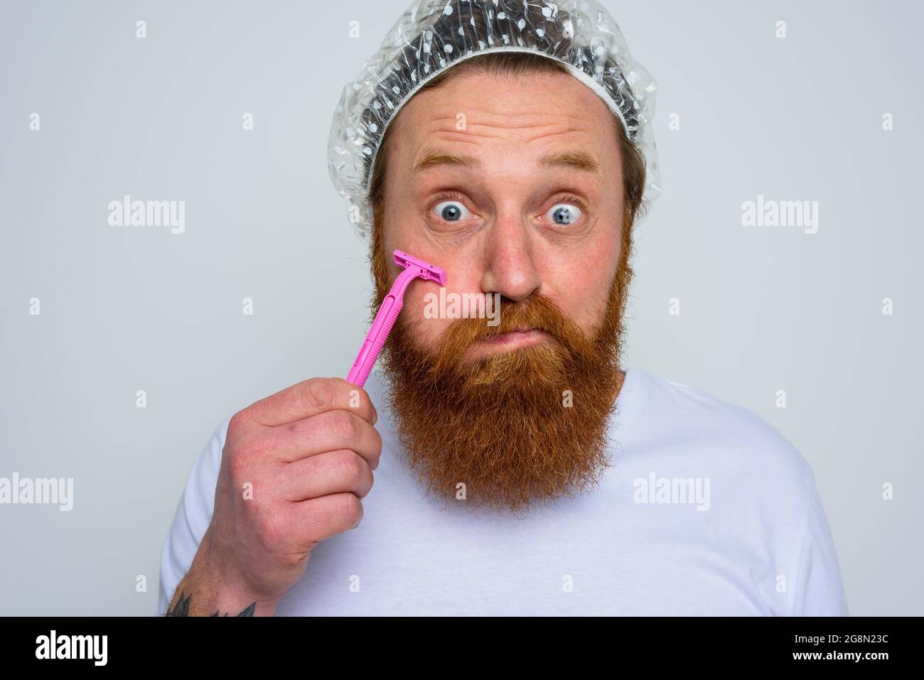 El hombre ajusta la barba con una cuchilla de afeitar Foto de stock