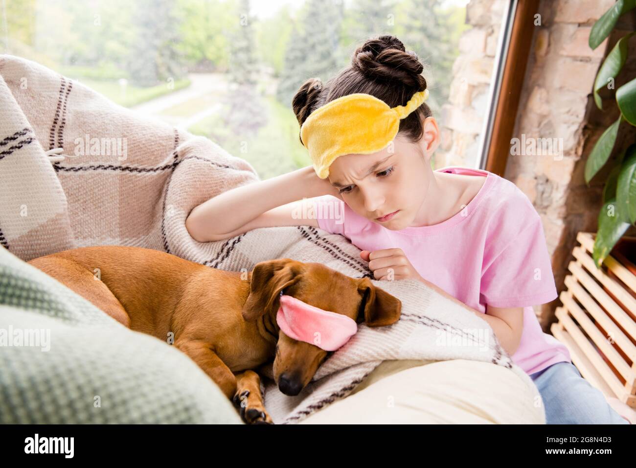 Foto de encantadora educada colegiala vestida camiseta rosa máscara para  dormir mirando perro marrón interior habitación casa Fotografía de stock -  Alamy
