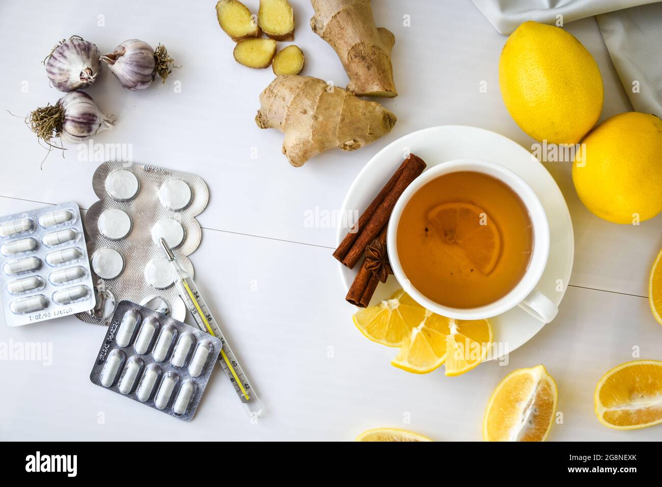 Productos para el tratamiento del frío común - limón, jengibre, té de manzanilla. Vitamina bebida natural. Estrella de anís canela. Medicina natural vs. Convencional Foto de stock