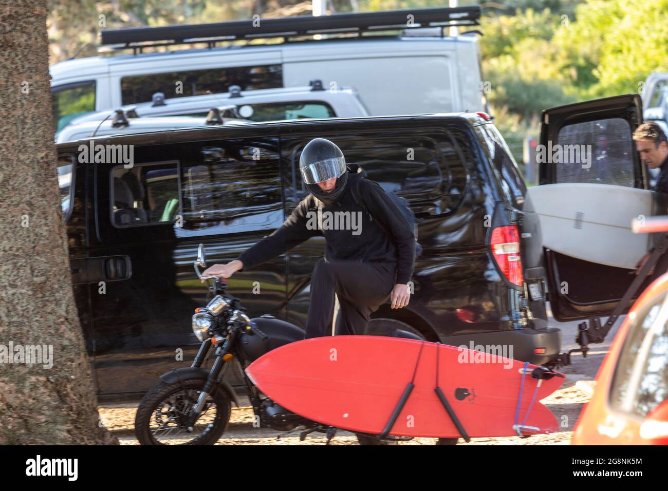 Motorista llevando su tabla de surf en su moto,Sydney,Australia Foto de stock