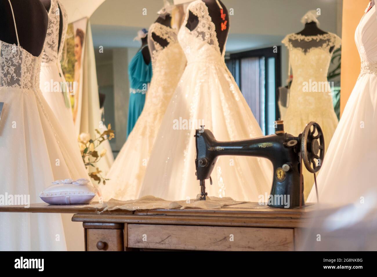Detalle de sastrería para vestidos de novia con una máquina de coser y ropa  blanca. No hay personas visibles, el fondo está borroso Fotografía de stock  - Alamy