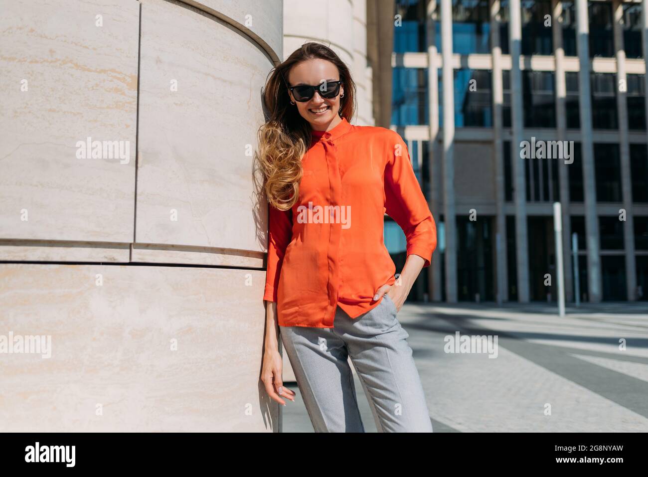 Chica caucásica en gafas de sol y ropa informal en una ciudad de verano Foto de stock