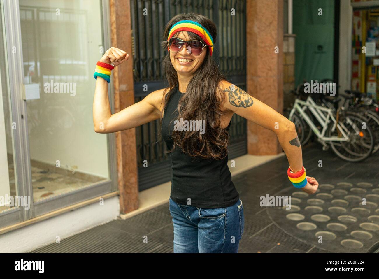 Mujer italiana fresca con muñeca LGBT y diadema mostrando su músculo sobre  un fondo borroso Fotografía de stock - Alamy
