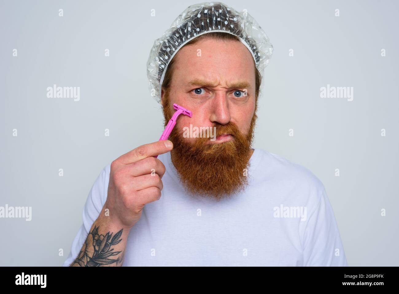 El hombre ajusta la barba con una cuchilla de afeitar Foto de stock