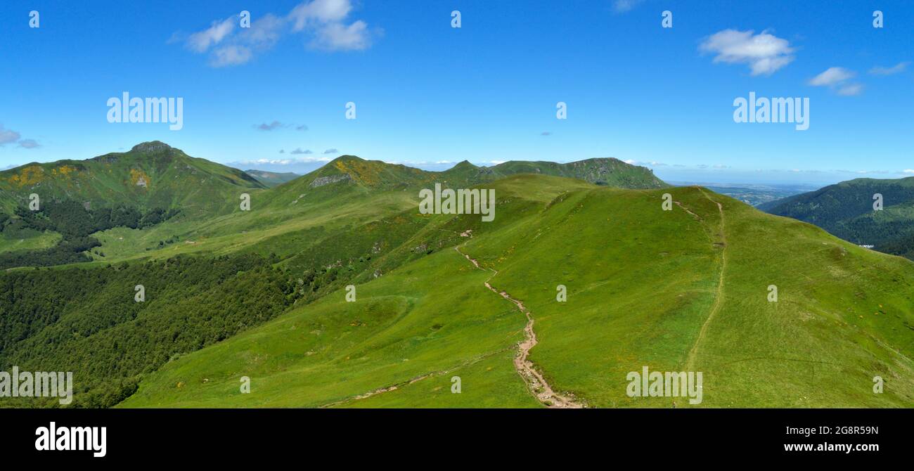 Hermoso paisaje verde en la cima de una montaña con una vista de una montaña volcánica panorama Foto de stock