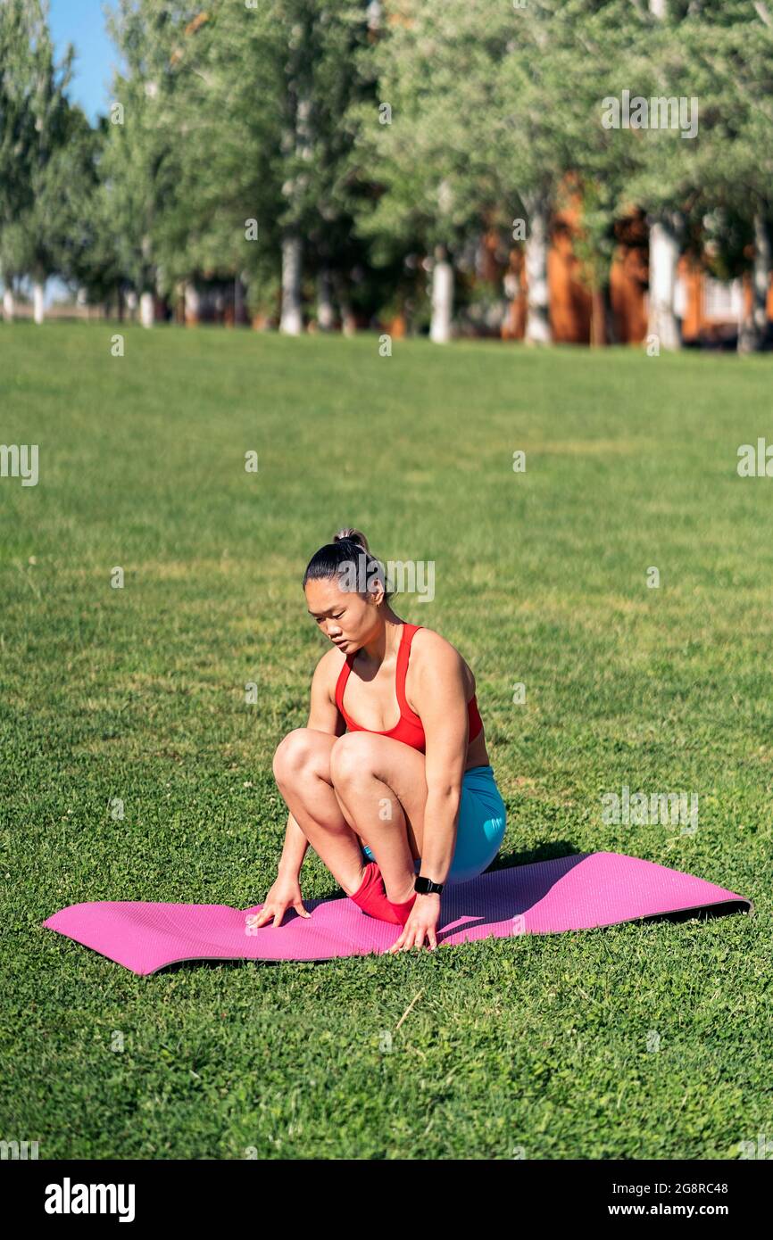 Mujer activa que usa ropa deportiva apoyándose en los músculos del cuerpo  de entrenamiento de fitball de yoga durante el entrenamiento de pilates  trabajando en el bienestar entrenador personal en ropa deportiva