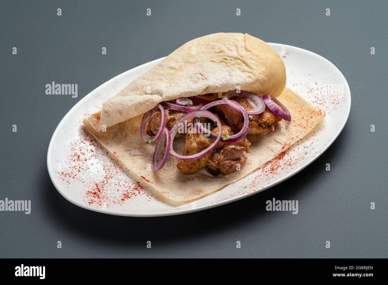 shashlik o carne a la parrilla con cebolla en pita sobre plato blanco sobre  fondo gris Fotografía de stock - Alamy