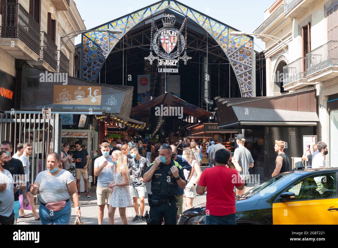 Barcelona, España; 19th de julio de 2021: Grupo de turistas que entran en el mercado de la Boqueria en Barcelona, con presencia policial, en pleno aumento en la incidencia de Foto de stock