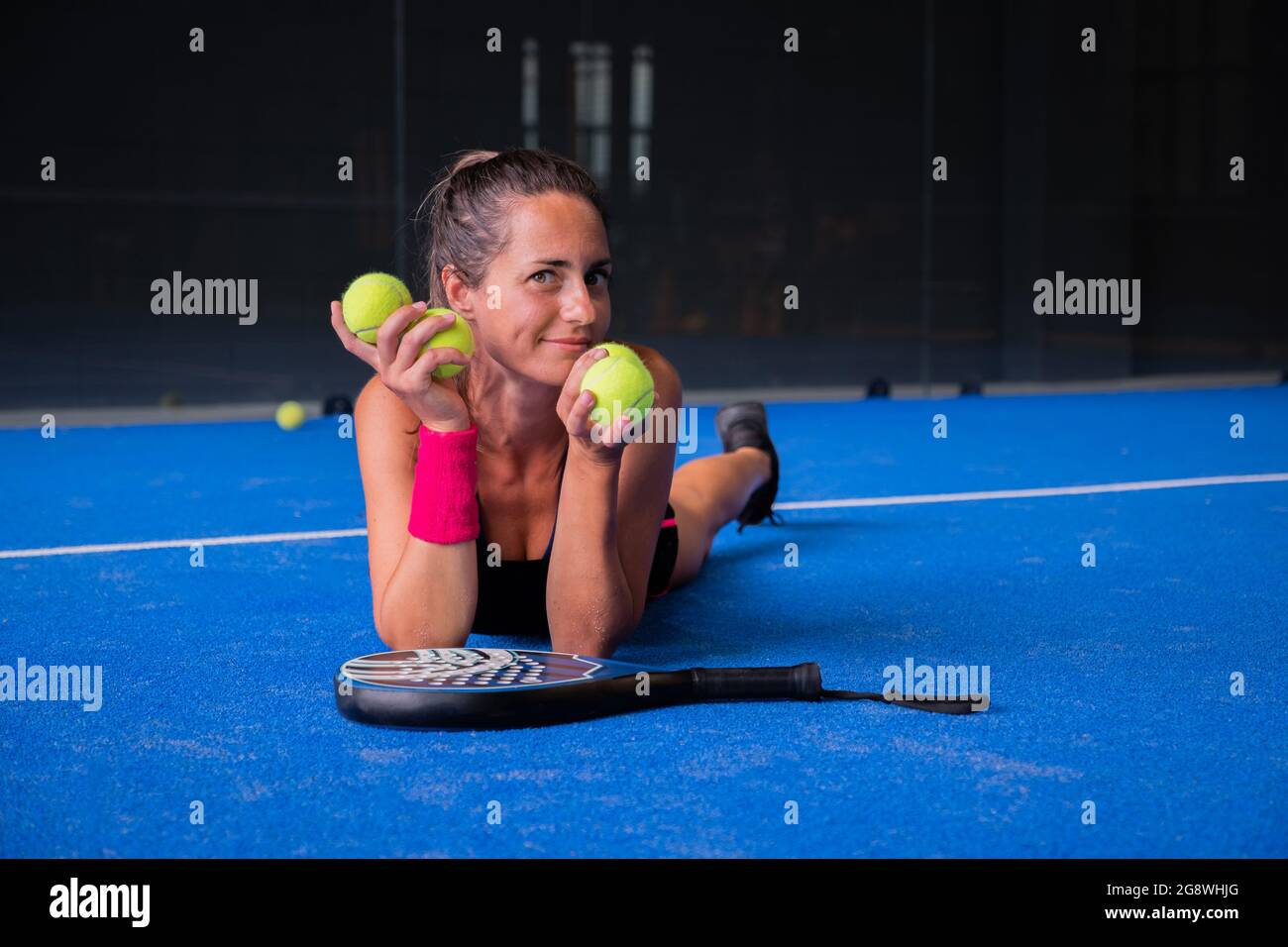 Retrato de una mujer hermosa jugando pista de padel tenis interior Foto de stock