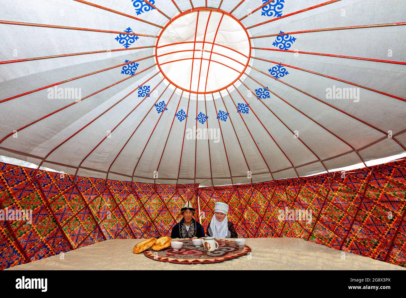 Kirguís se une con ropa local, en una tienda nómada conocida como yurt, cerca de Bishkek, Kirguistán. Foto de stock