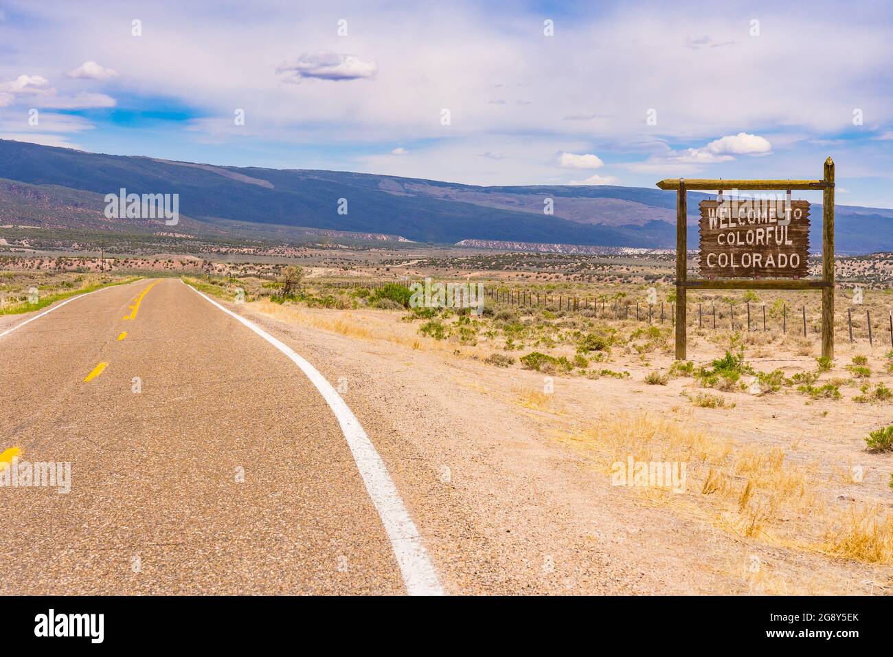 Bienvenido al colorido cartel de Colorado a lo largo de una larga carretera en la frontera de Colorado y Utah. Foto de stock