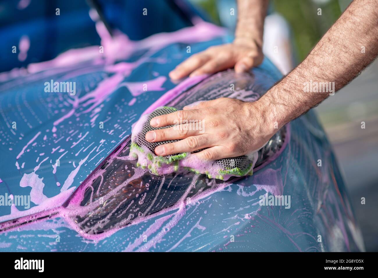 Hombre lavando la superficie del coche con paño Foto de stock
