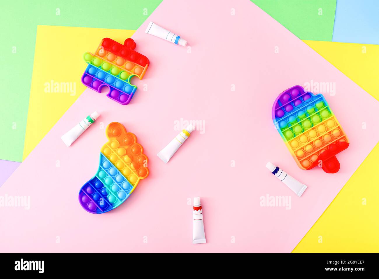 Nueva moda popular silicona colorido anti estrés Pop Juguetes para niños y pinturas sobre fondo colorido. Foto de stock