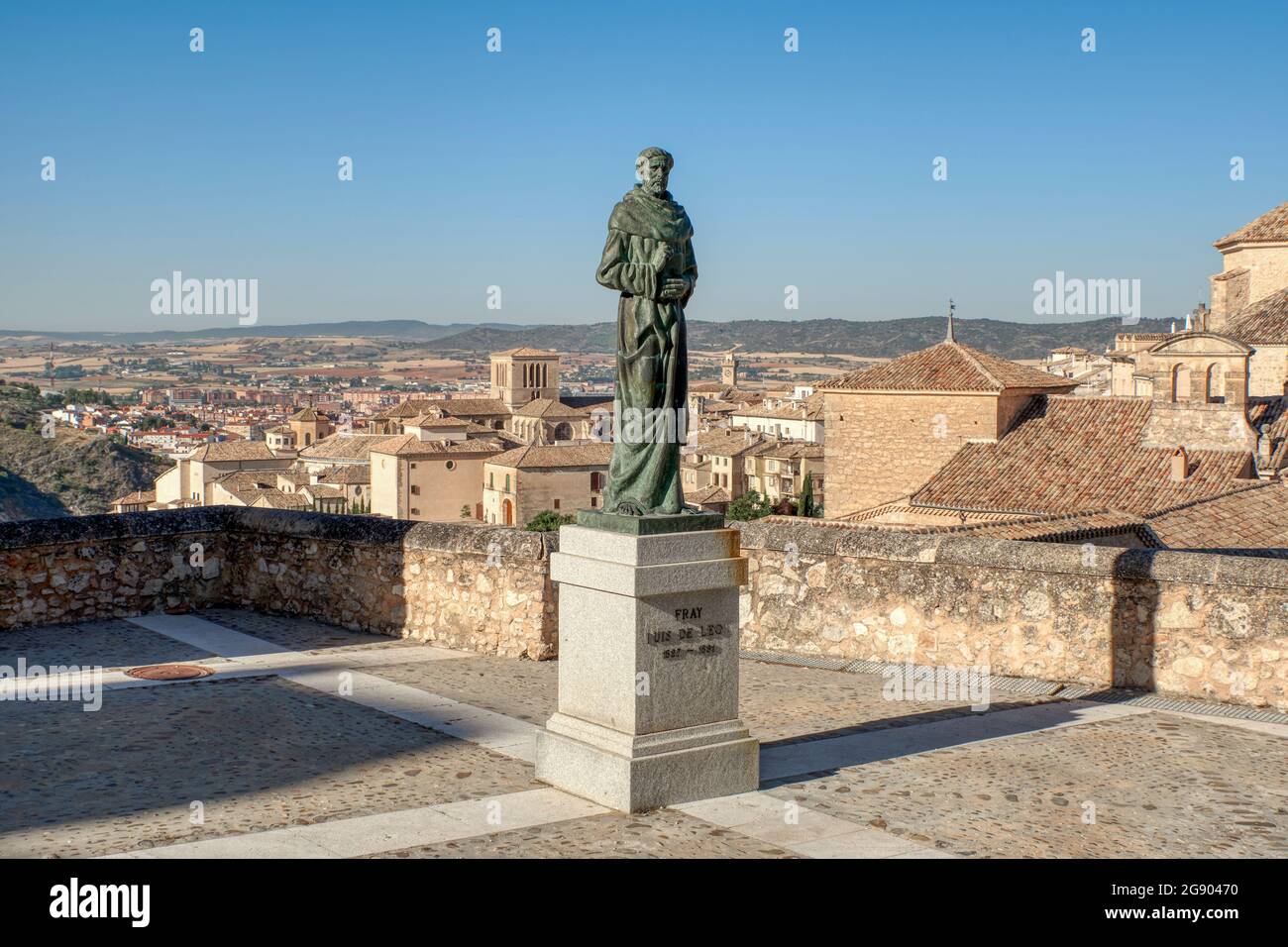 Escultura de Fray Luis de León realizada en bronce por el escultor Javier Barrios y la iglesia de San Pedro en el fondo. Cuenca, Castilla la Mancha, España Foto de stock