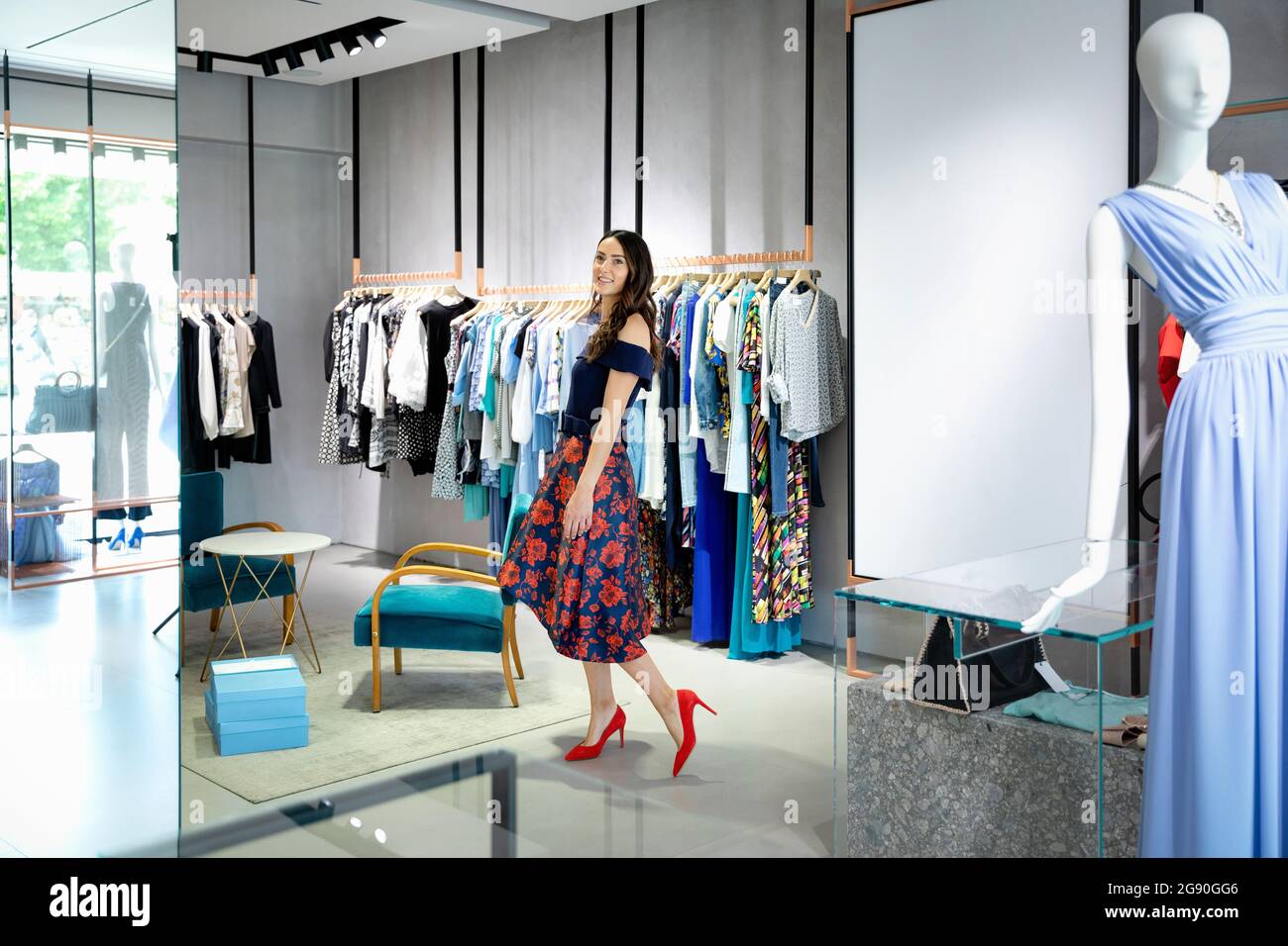 Mujer joven tratando de vestir elegante en la boutique Fotografía de stock  - Alamy
