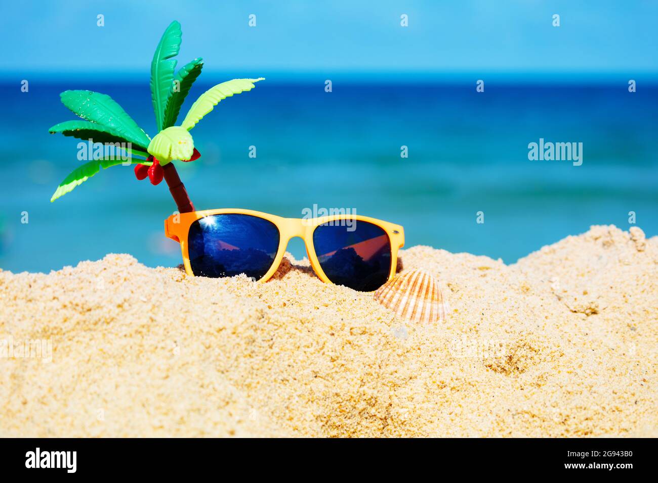 Gafas de sol para niños y palma de juguete en la arena en la playa del mar  Fotografía de stock - Alamy