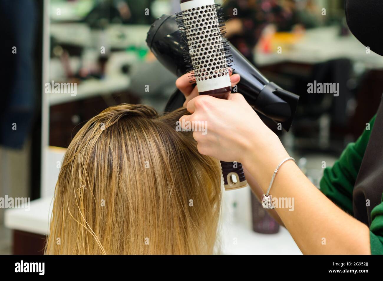 Secado del cabello con secador de pelo y cepillo redondo, procedimientos de  peluquería. Nuevo Fotografía de stock - Alamy