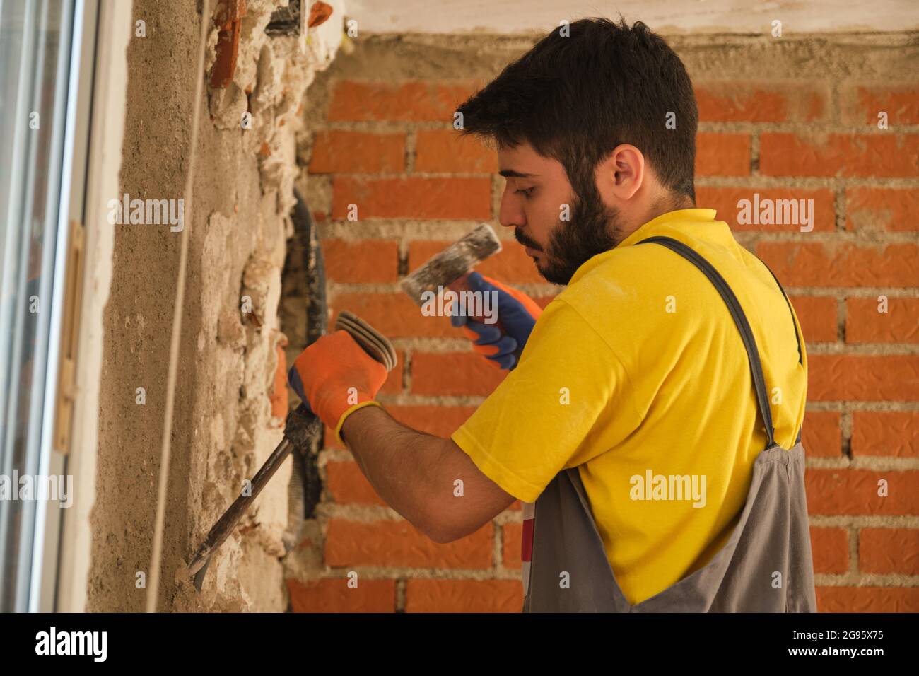 Trabajador Con Un Martillo Eléctrico. El Hombre Hace Un Nicho En La Pared  De Ladrillos. Fotos, retratos, imágenes y fotografía de archivo libres de  derecho. Image 103392405