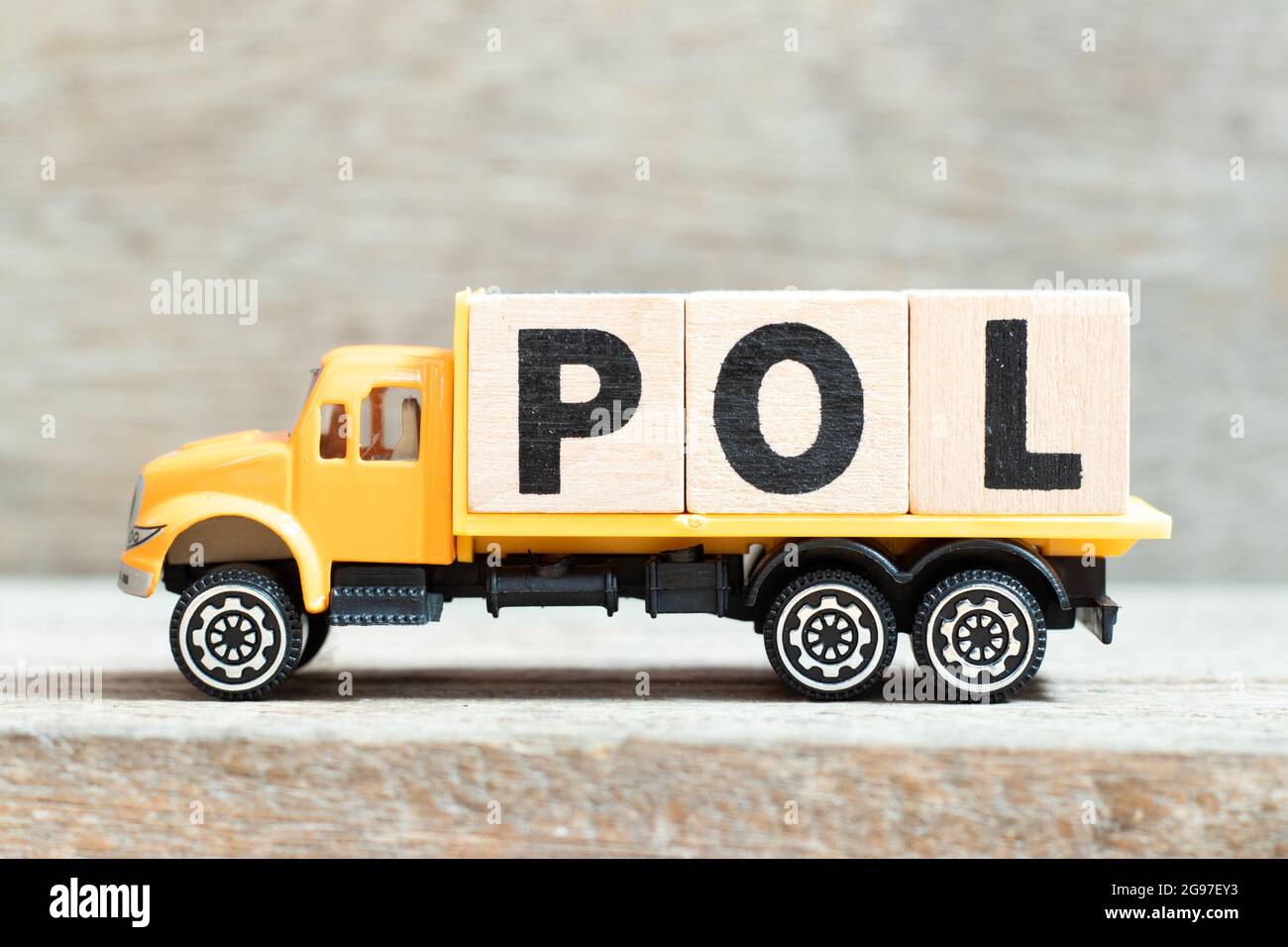 Camión de juguete sostener el bloque de letras del alfabeto en la palabra  POL (Abreviatura del puerto de carga o precio en línea) sobre fondo de  madera Fotografía de stock - Alamy