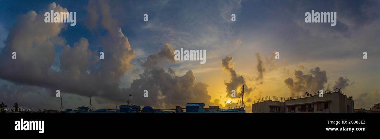 Panorama de la hora dorada realizado con varias fotos cosidas y editadas para mostrar el horizonte durante la puesta de sol. Foto de stock