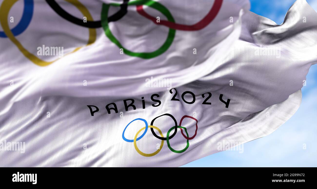 Tokio, Japón, 2021 de julio: La bandera de París 2024 ondeando en el viento con la bandera olímpica borrosa en el primer plano. Los Juegos olímpicos de verano de París 2024 son juegos de azar Foto de stock