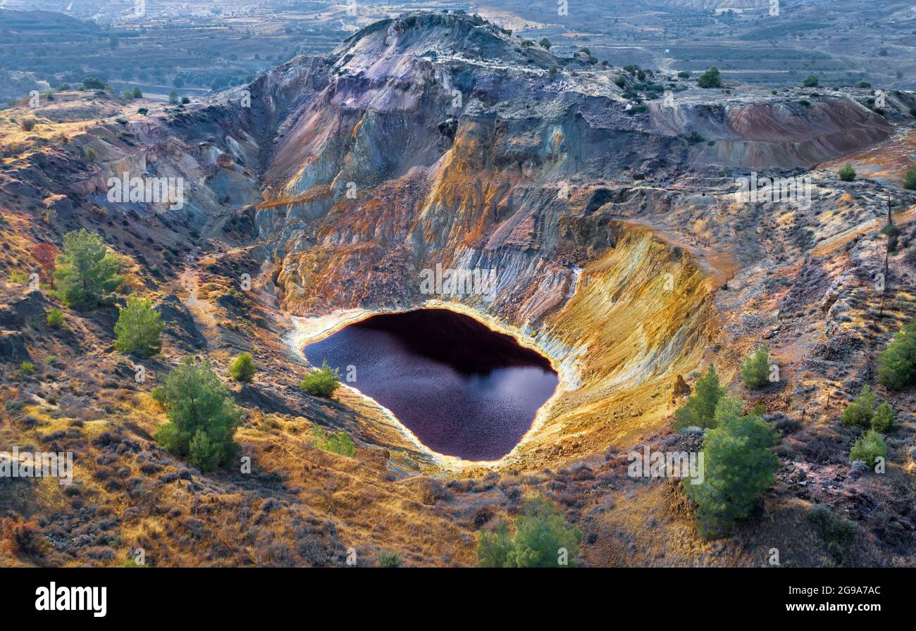 El lago rojo ácido y las rocas coloridas en la mina abandonada cerca de Kampia, Chipre. Esta área tiene grandes cantidades de mineral de cobre y depósitos de sulfuro Foto de stock