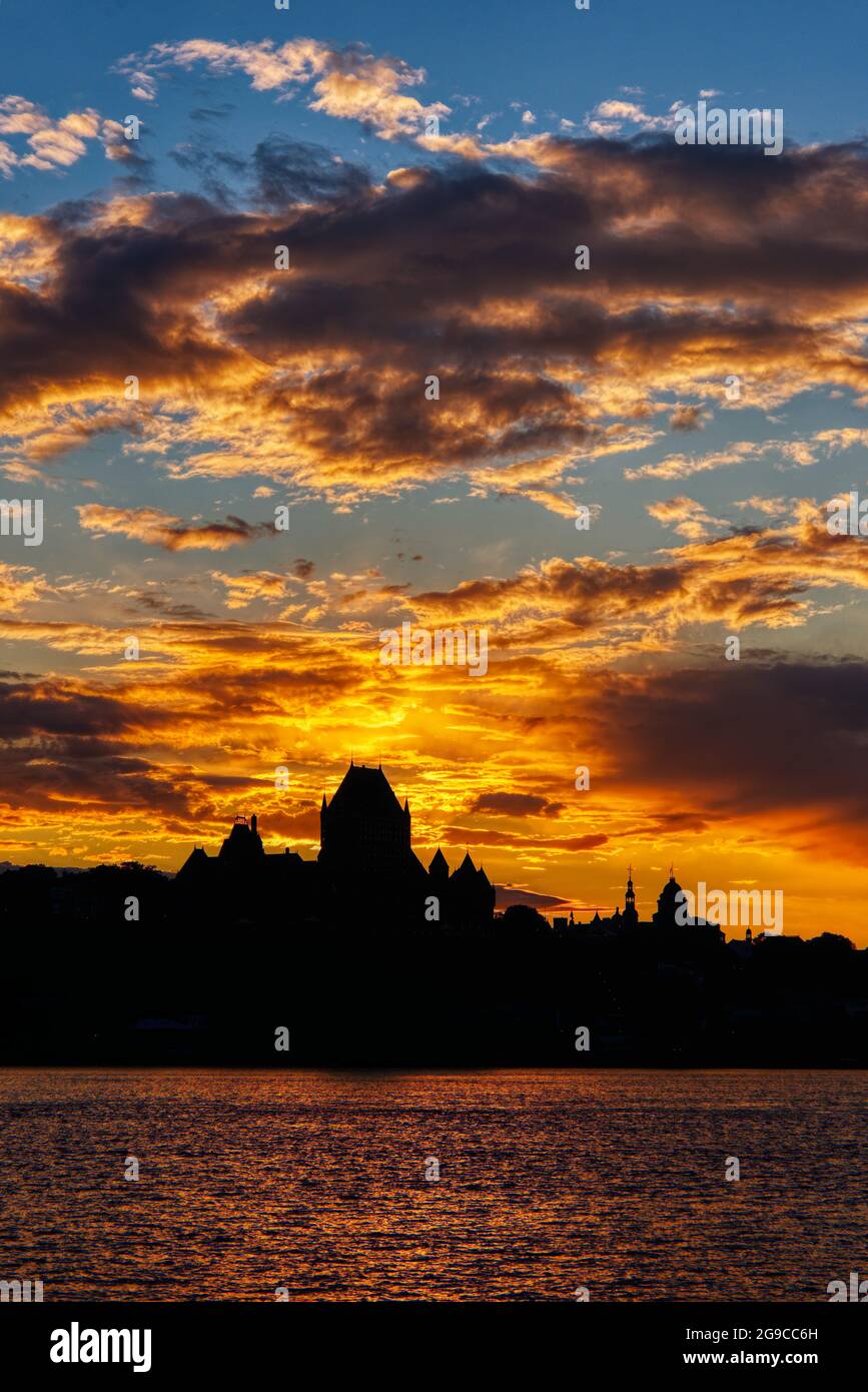 El horizonte de la ciudad de Quebec se perfila contra una ardiente puesta de sol, vista desde Lévis, Canadá Foto de stock