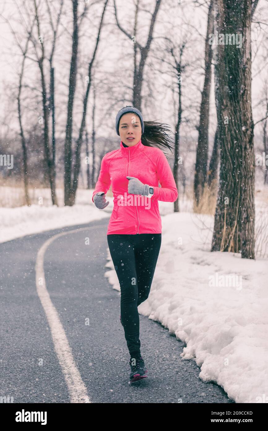 Ejercicio de invierno Mujer asiática corriendo con ropa de clima frío. Chica corredor china entrenando fuera. Atleta haciendo ejercicio en parque durante Fotografía de stock Alamy