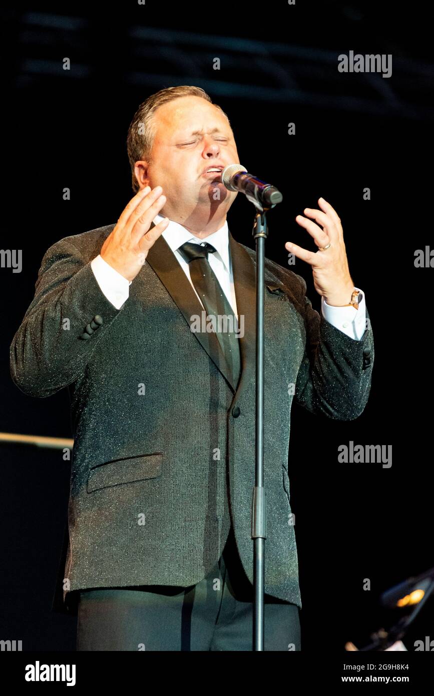 Paul Potts actuando en el escenario en Maldon, Essex, Reino Unido. Cantante de tenor operístico galés, cantando con la Orquesta de Concierto de Londres después del cierre de COVID Foto de stock