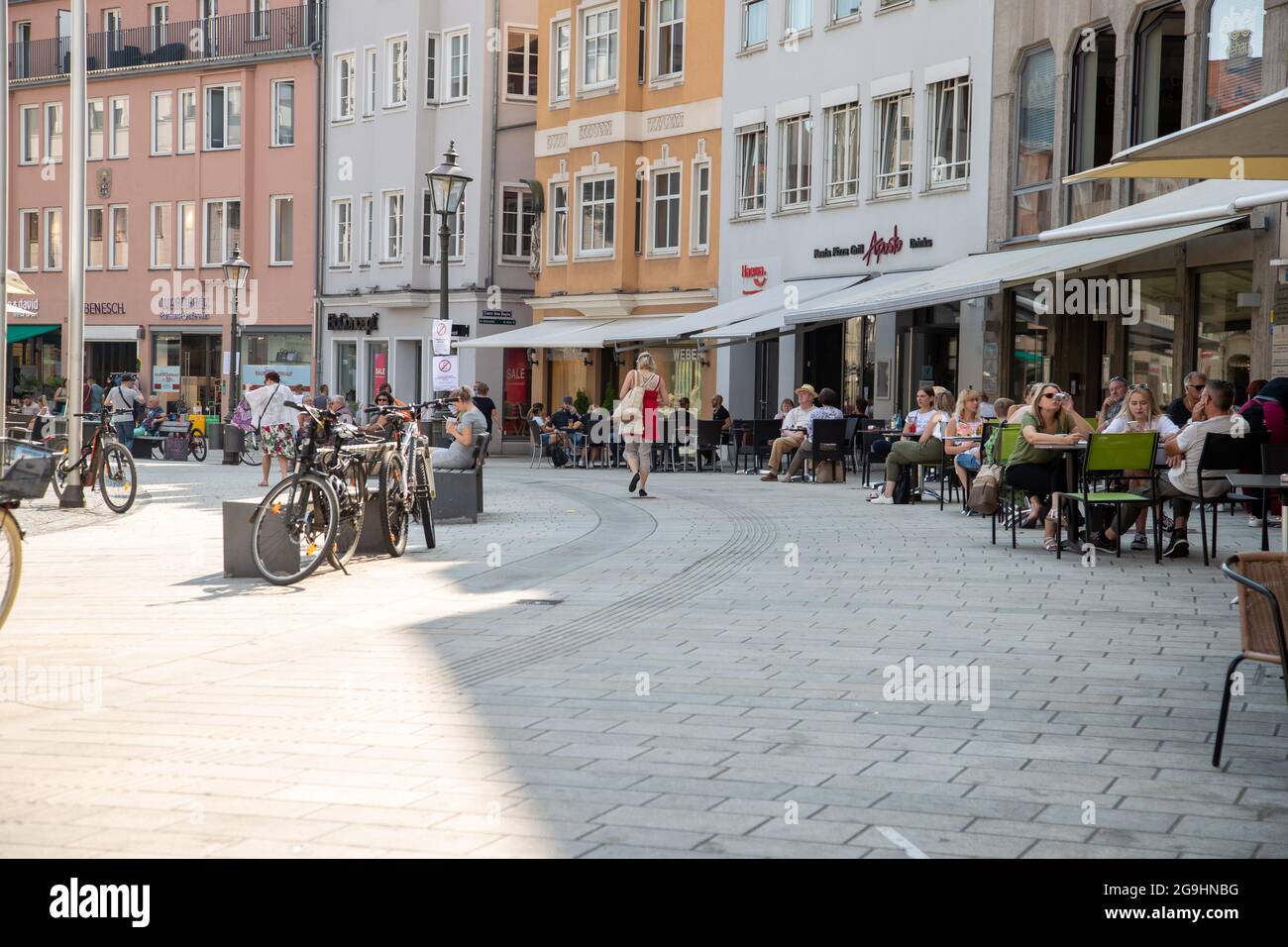 Menschen füllen am 26.7.2021 die Innenstadt und Cafés en Augsburgo en Schwaben. Die Corona Infektionen sind bundesweit weiterhin leicht am Steigen. Die Zahl der Menschen, die sowohl ihre erste Impfung bekommen haben als auch durchgeimpft sind, steigt weiter an. Manche Politiker denken öffentlich über Einschränkungen für Impfverweigerer nach. - La gente llena el centro y los cafés de Augsburg en Swabia, Alemania. El número de infecciones por covid en Alemania está aumentando de nuevo ligeramente. Cada vez más personas se vacunan. Algunos políticos están pensando públicamente en las restricciones Foto de stock