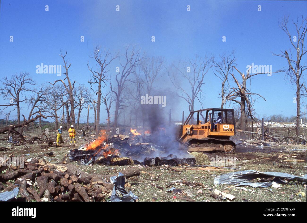 Brenham Texas USA, abril de 71992: La bulldozer elimina escombros después de que una explosión de un gasoducto de gas natural arrasara un área rural fuera de Brenham, matando a una persona y a varias cabezas de ganado, e hiriendo a una veintena de personas. ©Bob Daemmrich Foto de stock