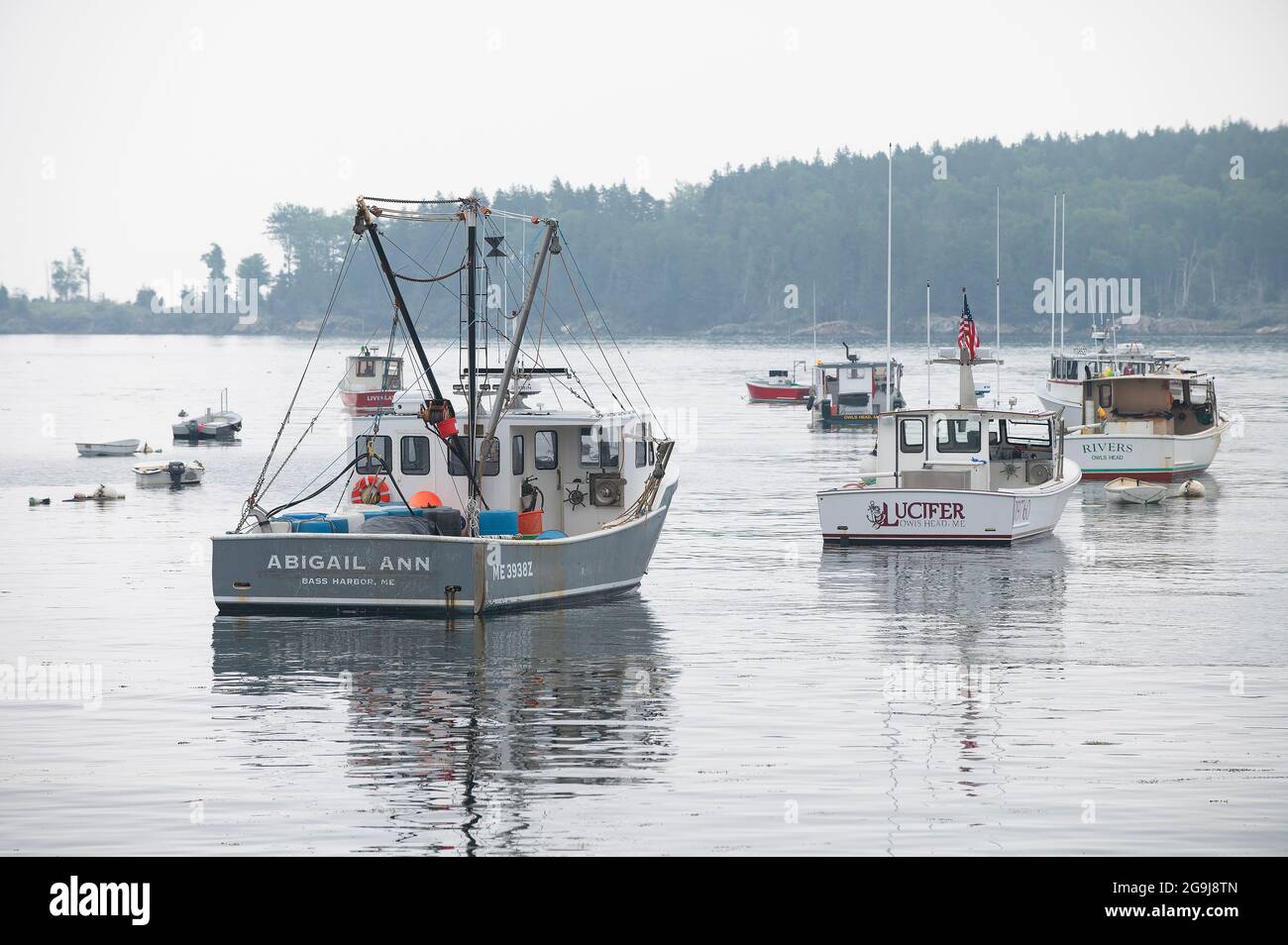 Barcos comerciales de langosta en sus amarres en una mañana niebla en Owls Head, Maine, Estados Unidos Foto de stock