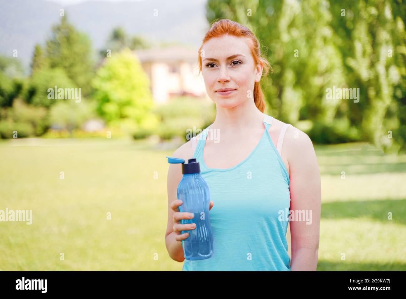 Una joven mujer de fitness que lleva ropa deportiva entrenando agua potable  al aire libre Fotografía de stock - Alamy