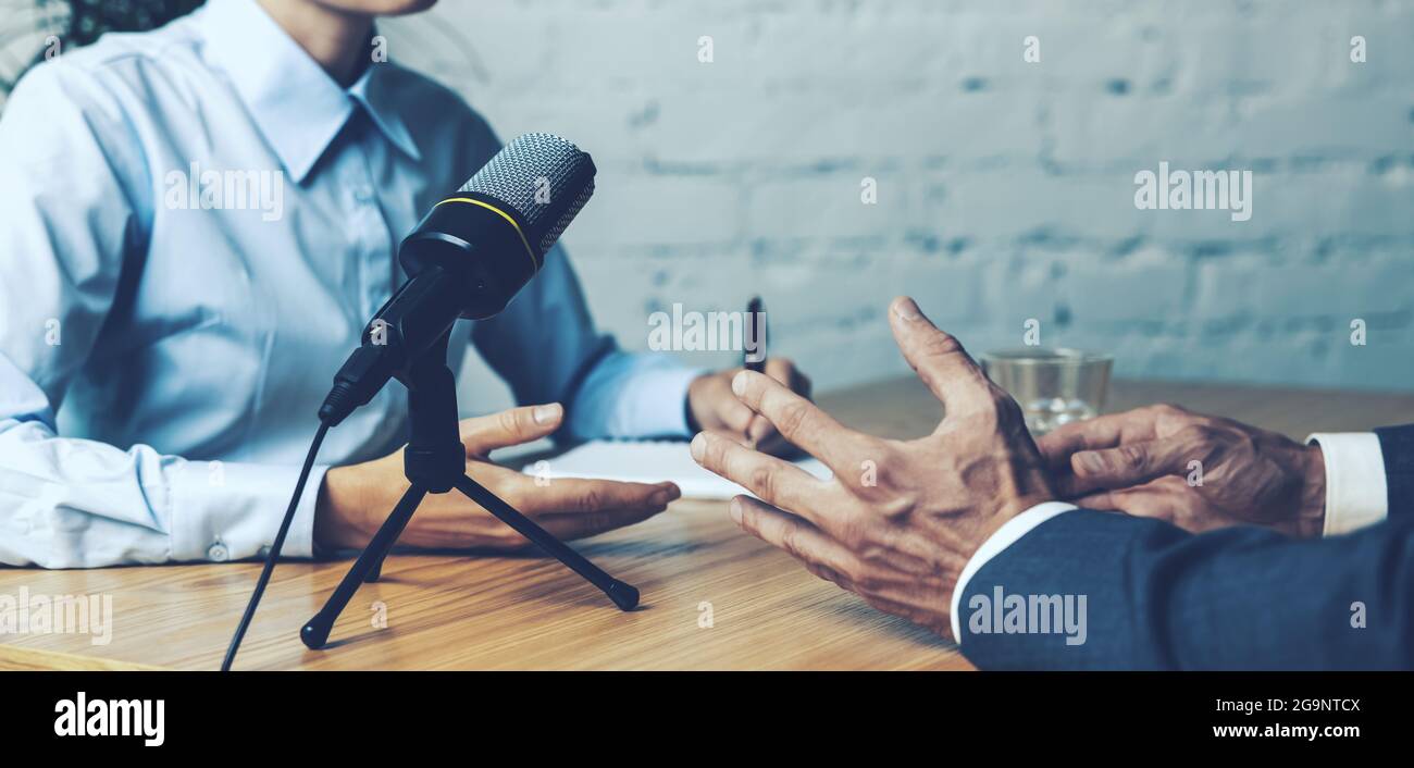 grabación de la entrevista de podcast - la discusión del anfitrión de la radio con el empresario en el estudio de la radiodifusión. espacio de la copia de la bandera Foto de stock