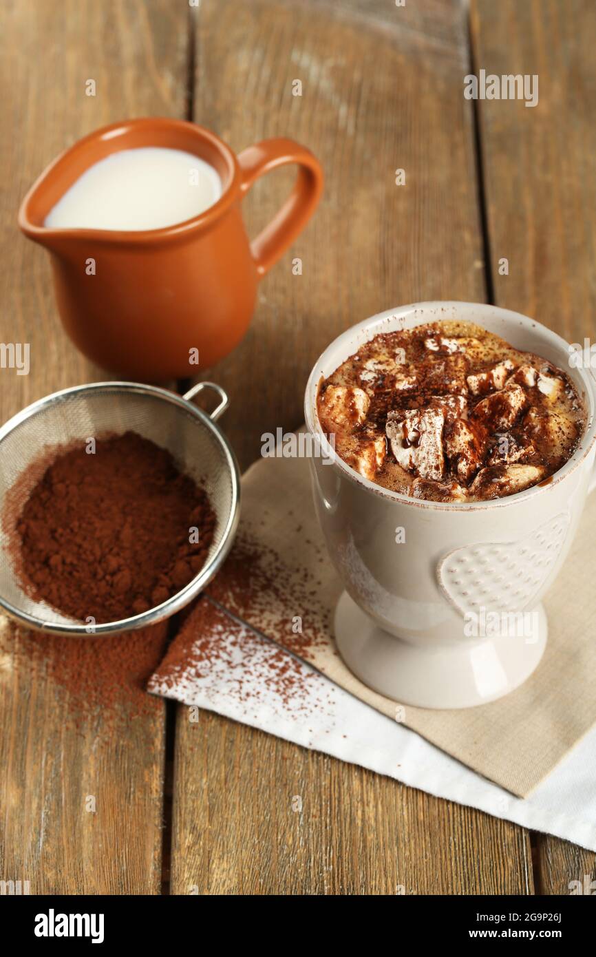 Taza de café caliente con malvavisco y taza de leche con colador de cacao  sobre servilleta y fondo de tablones rústicos de madera Fotografía de stock  - Alamy