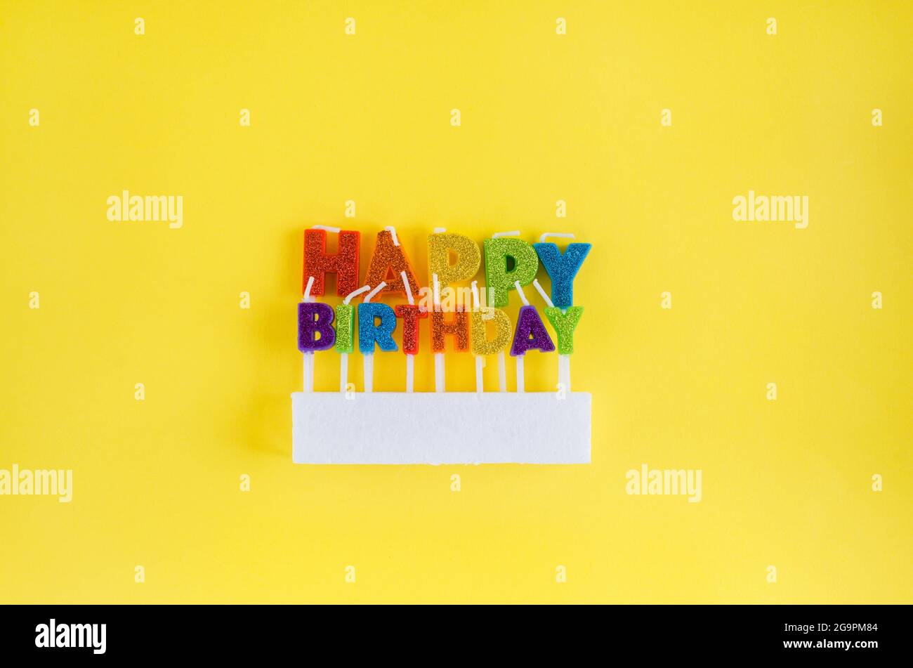 velas de colores para pastel 'feliz cumpleaños' sobre fondo amarillo.  Concepto paty, vacaciones Fotografía de stock - Alamy