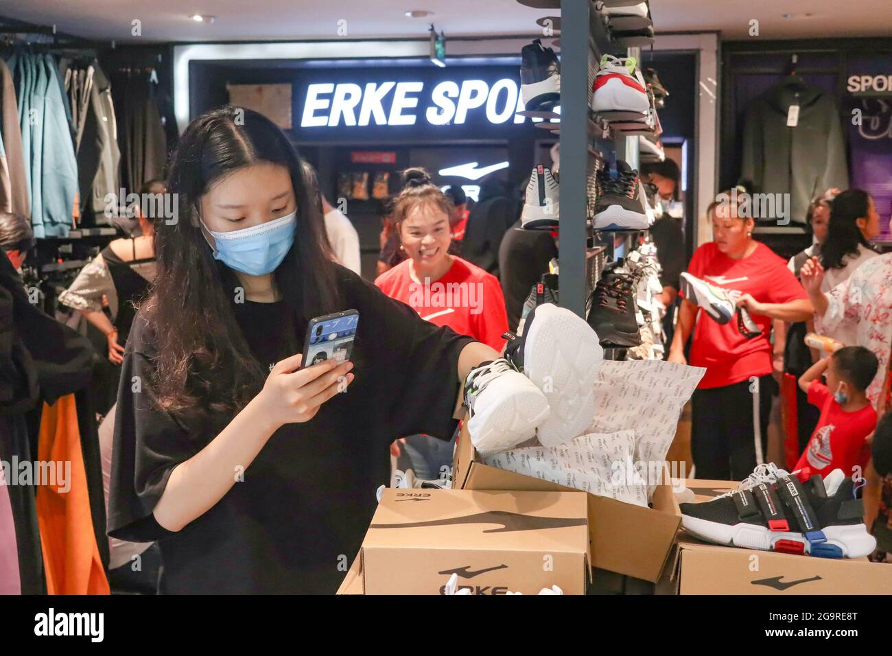 La gente compra en la tienda de ropa deportiva china Hongxing erke en la  ciudad de Hangzhou, en la provincia de Zhejiang, en el este de China, el 27  de julio de