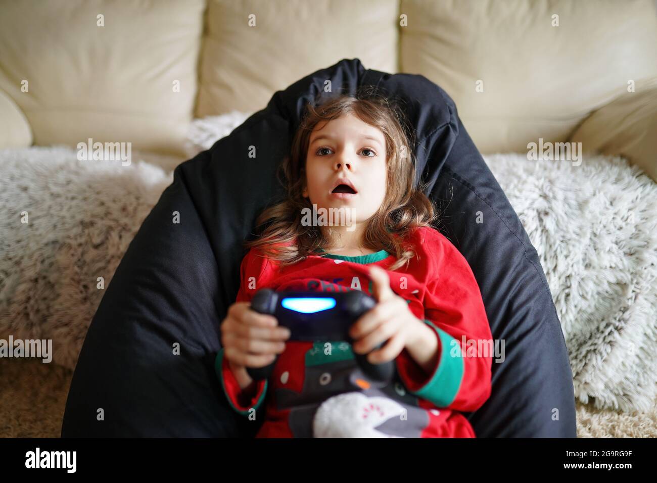 Una chica de juegos jugando gamepad, joystick en juegos en pantalla grande. Ciberdeporte. Un juego de estrategia y acción Foto de stock