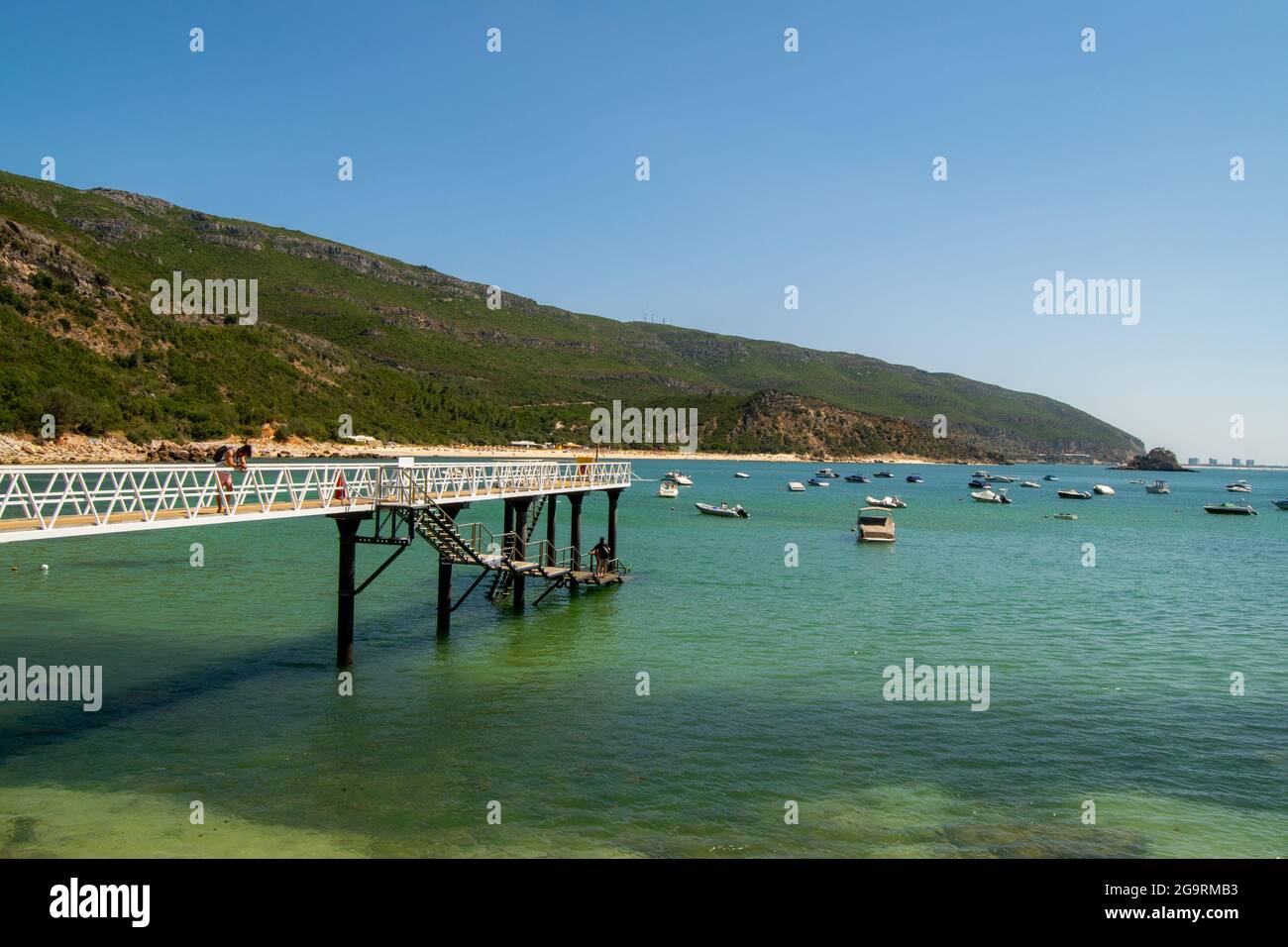 Puente de playa Portinho da Arrábida en Setúbal, Portugal. Puente de acero sobre el océano en el puerto de barcos. Arrábida parque natural. Foto de stock