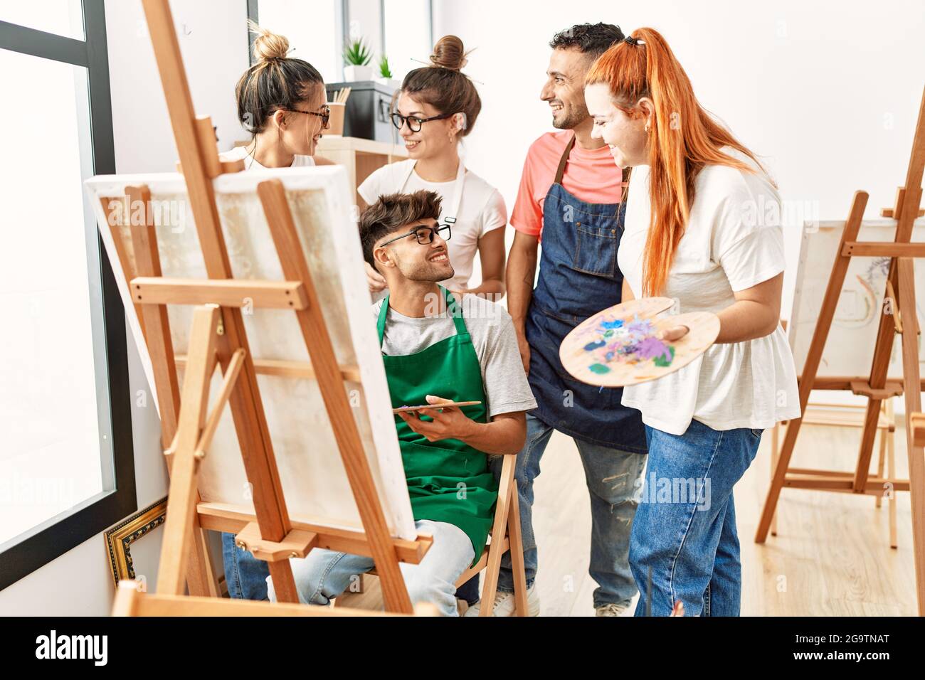 Grupo de jóvenes estudiantes de pintura sonriendo feliz y mirando el dibujo  de socio en el estudio de arte Fotografía de stock - Alamy