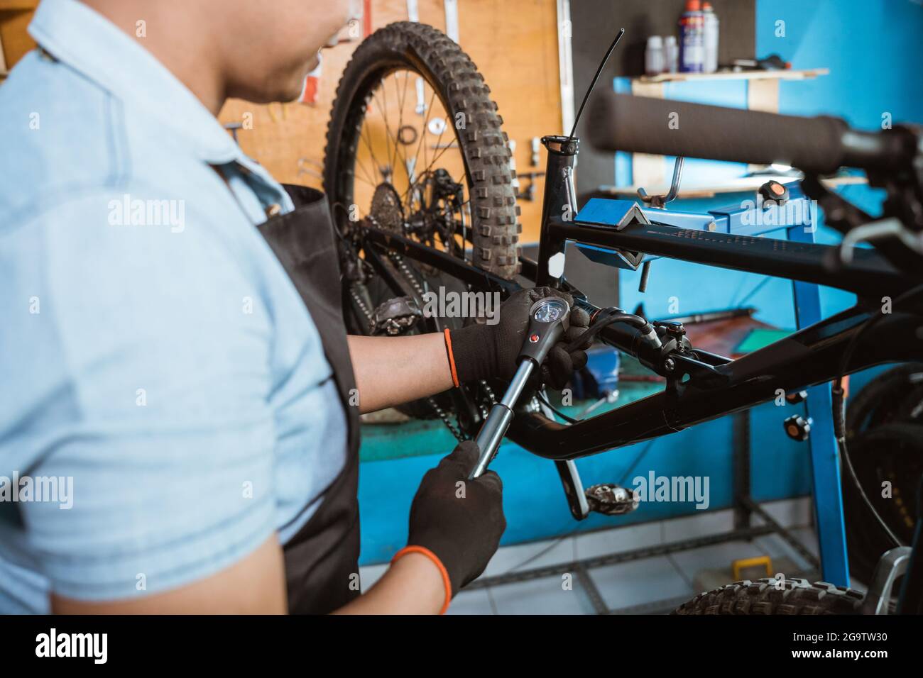 mano mecánica en guantes con una bomba de bicicleta con manómetro para  ajustar la suspensión trasera Fotografía de stock - Alamy