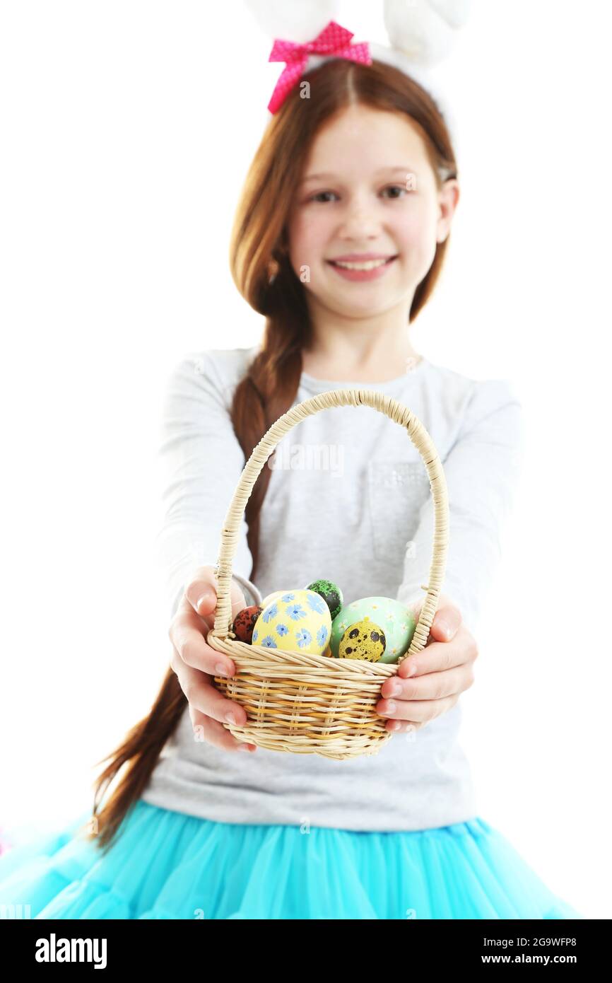 Hermosa niña vestidos de orejas de conejo de Pascua y la celebración de  canasta de mimbre con huevos de Pascua, aislado en blanco Fotografía de  stock - Alamy