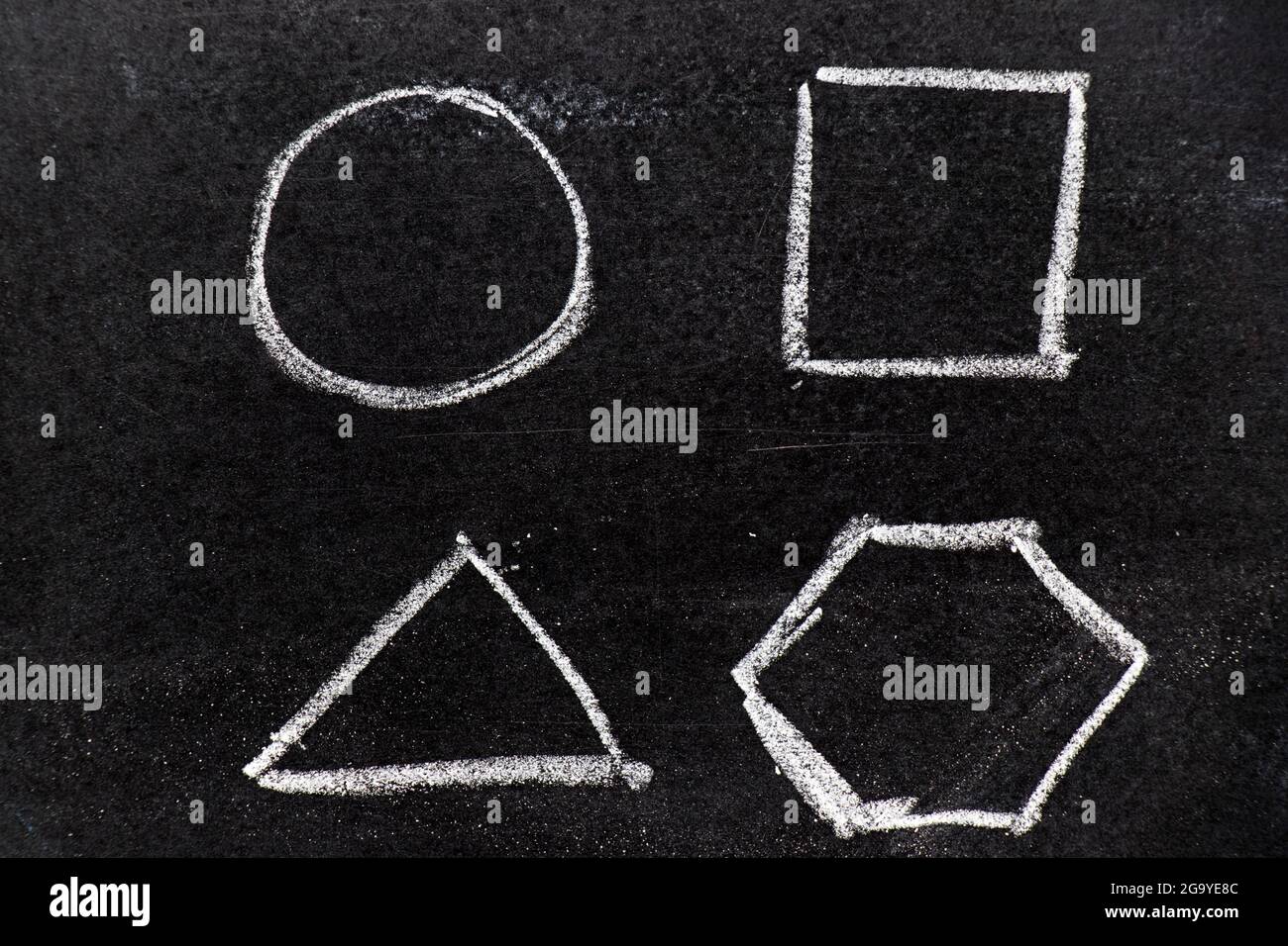 Dibujo a mano de tiza como forma geométrica (círculo, triángulo, cuadrado, hexágono) sobre fondo negro de tablero Foto de stock