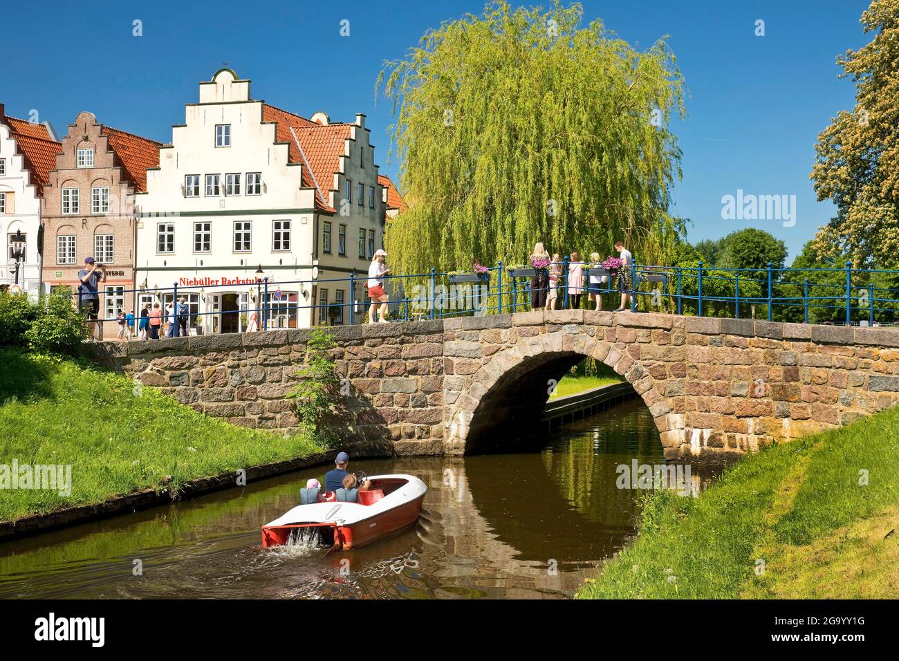 puente sobre la vía fluvial central Mittelburggraben con casas con tejados, Alemania, Schleswig-Holstein, Frisia septentrional, Friedrichstadt Foto de stock