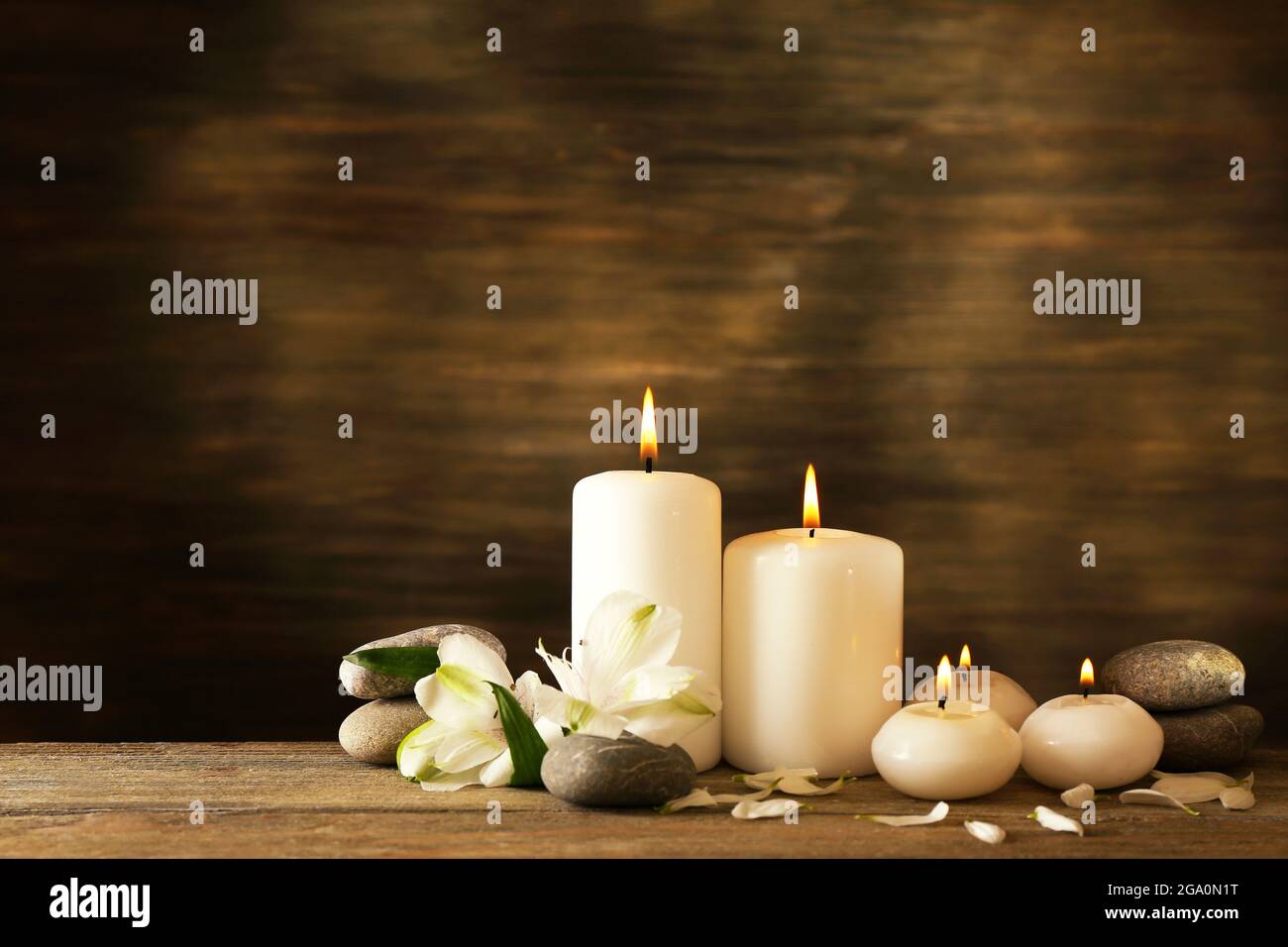 Hermosa composición con velas y spa piedras sobre fondo de madera  Fotografía de stock - Alamy