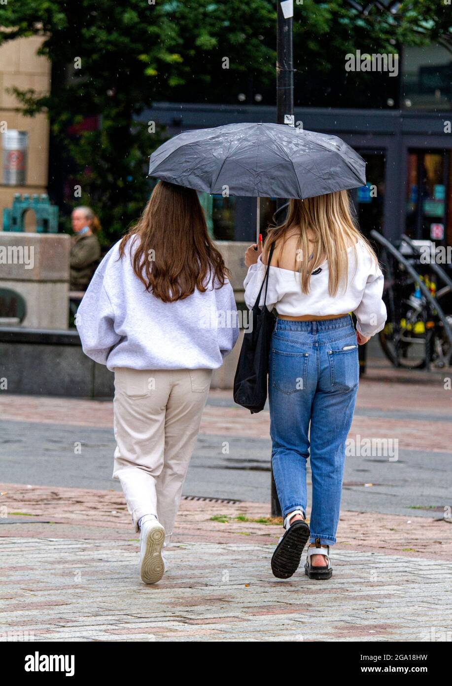 Una mujer joven con ropa abrigada parada en la calle en un clima