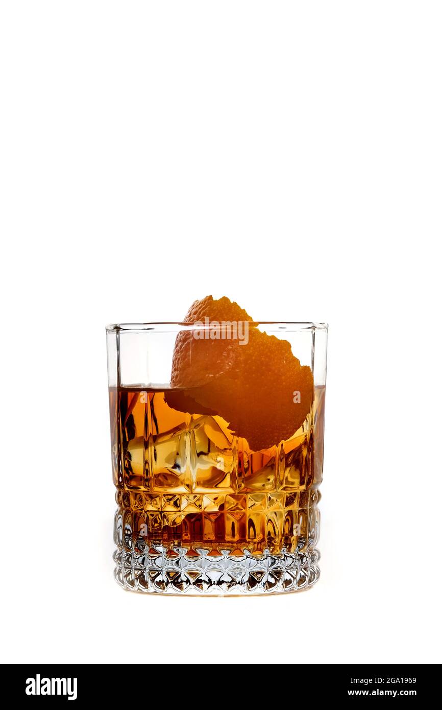 Whisky con hielo o brandy con naranja en vidrio aislado en fondo blanco. Bebida whisky con hielo en vaso. Whisky o brandy. Enfoque selectivo. Foto de stock