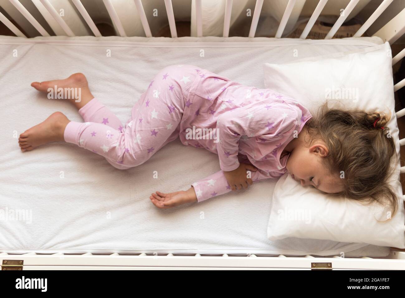 Vista superior Cute Little 3-4 años preescolar bebé niña niño durmiendo dulcemente en cuna blanca durante almuerzo tiempo de descanso en pijama rosa con almohada en casa Fotografía de stock - Alamy