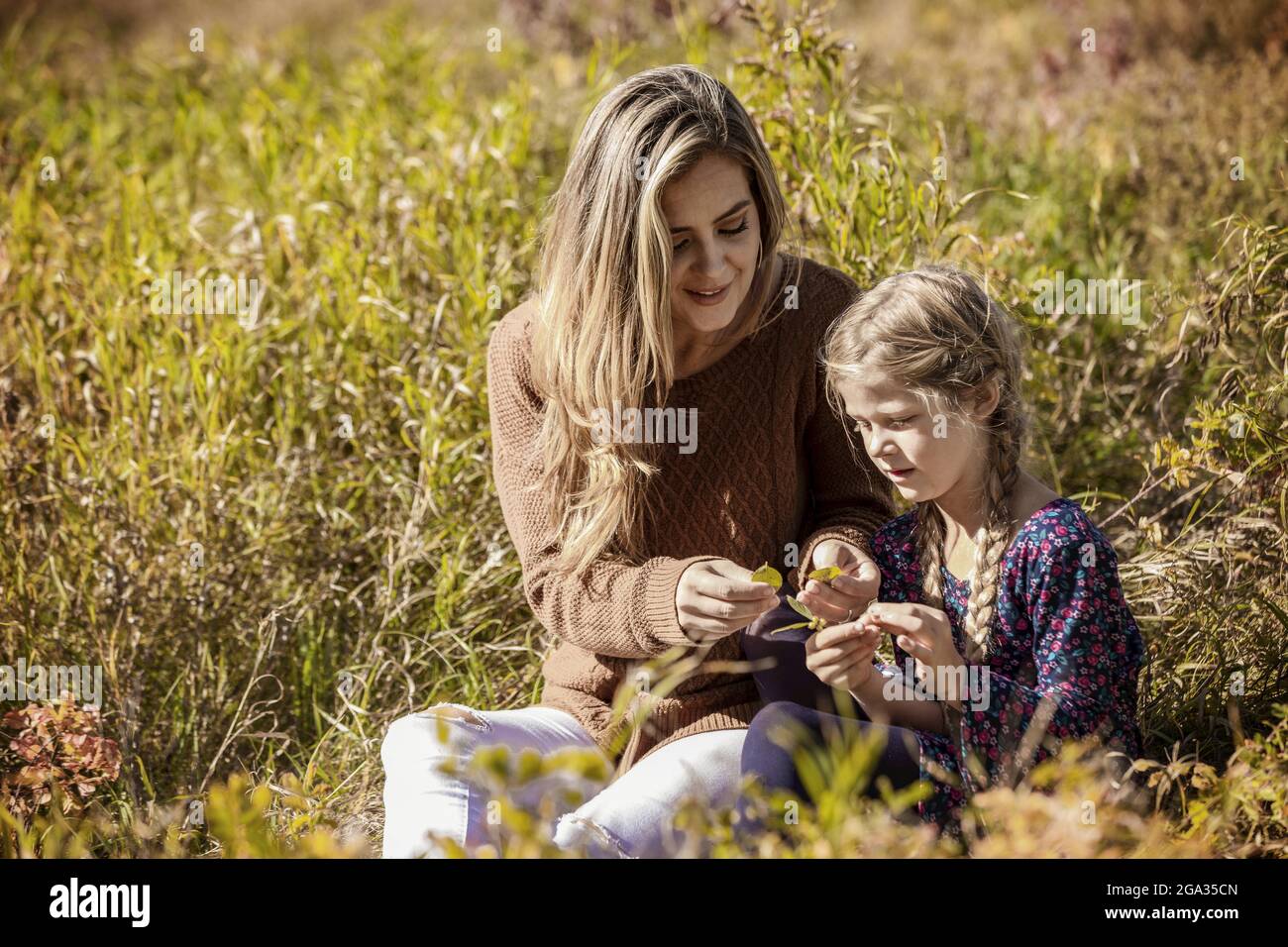 Una madre que pasa tiempo de calidad al aire libre con su hija en un parque de la ciudad; Edmonton, Alberta, Canadá Foto de stock